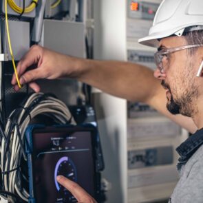 man-electrical-technician-working-switchboard-with-fuses-min